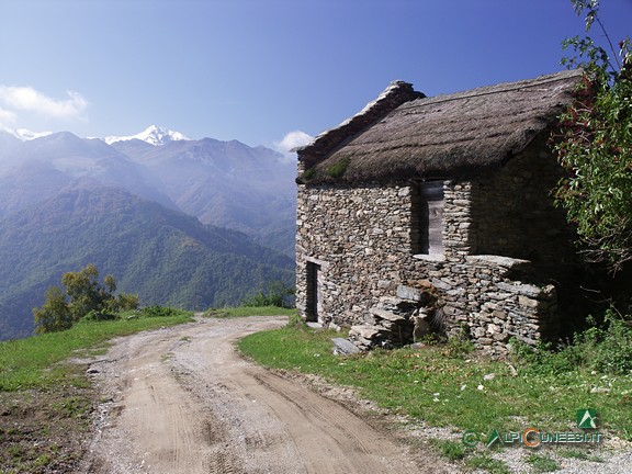 12 - Un fotomontaggio mostra come si poteva presentare il tetto racchiuso a Case Rosa con la copertura originale in paglia (2005)