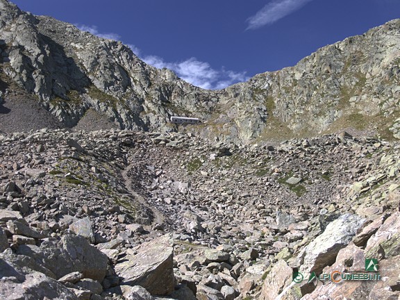 2 - L'inizio della zona prevalentemente detritica, con l'evidente sentiero rettilineo che l'attraversa; in alto al centro, il Passo di Barbacana (2020)